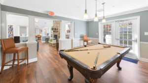 Interior Victoria Park at Edgewater billiards room, clubhouse room adjacent, wood floors, open floor plan.