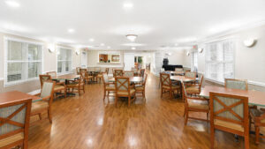 Interior Victoria Park at Edgewater Dining/Event room, 8 four person tables in room, wood floors, beige walls.